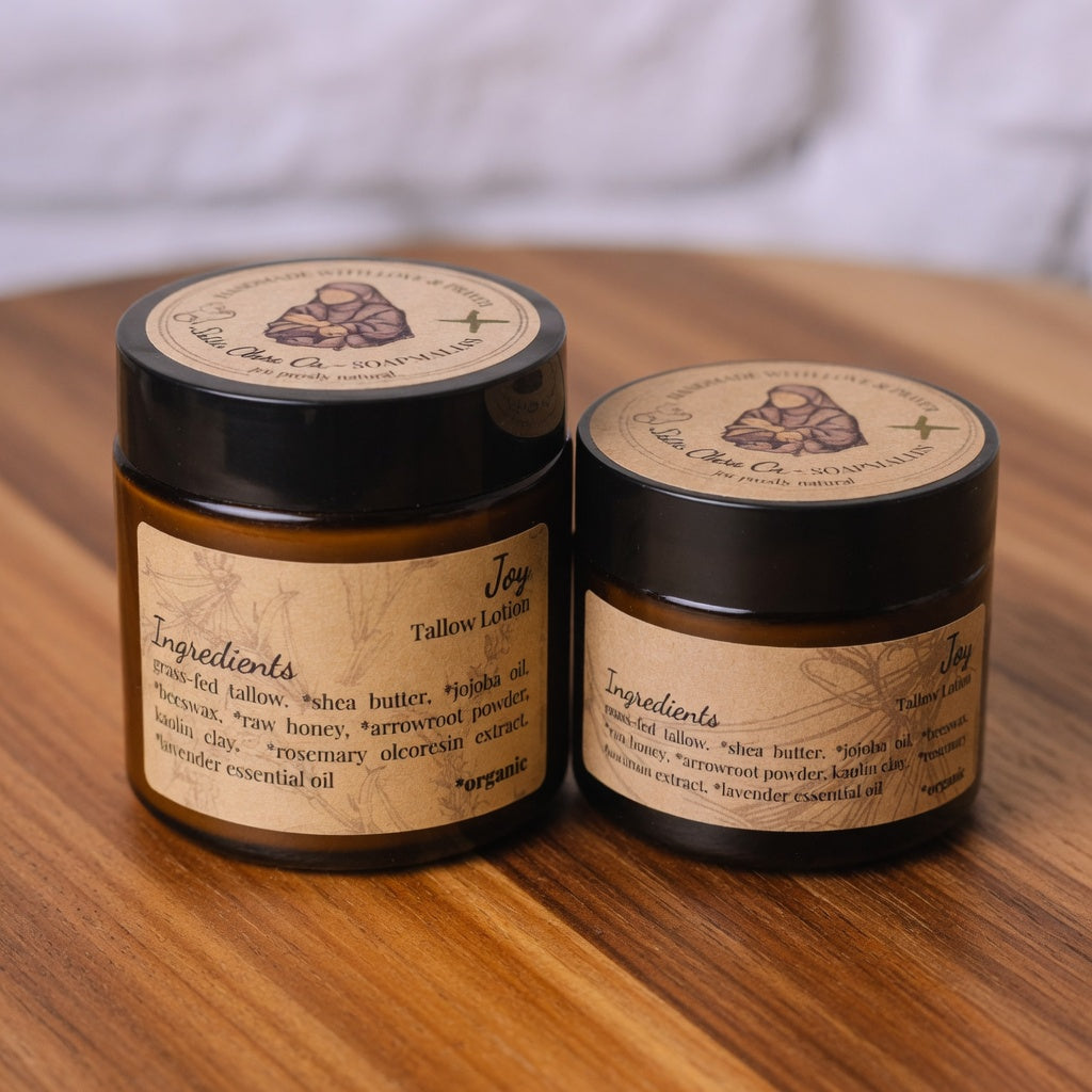 Joy Tallow Lotion hero product shot on warm wooden surface, showcasing the beautiful amber jar and label with unbridled joy theme
