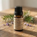 A 10 mL amber glass bottle of Radiant Hope Essential Oil Blend with a black ribbed cap and a beige label, set on a rustic wooden surface with sprigs of greenery and small purple flowers in the background.