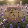 Bar of soap with a 'Joy' label surrounded by lavender flowers