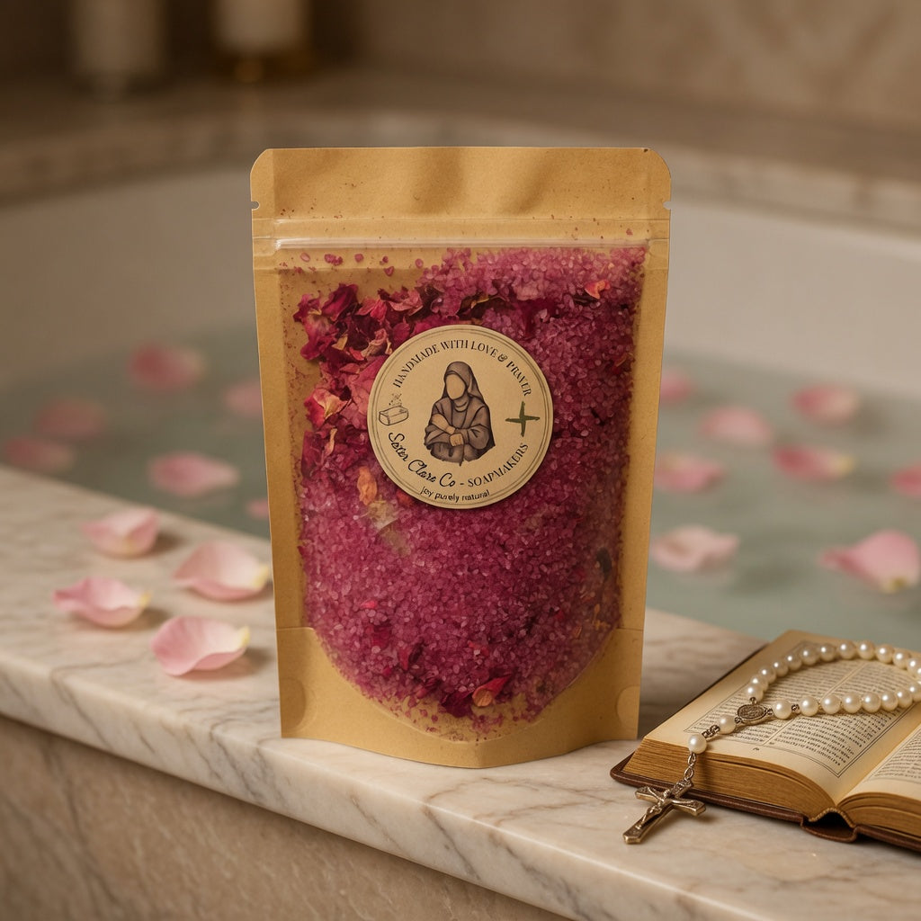 Square lifestyle photograph of Lisieux Mineral Soak pouch beside a cozy bath setting with roses and soft lighting, inspiring customers to imagine their own relaxing, spiritually uplifting soak.