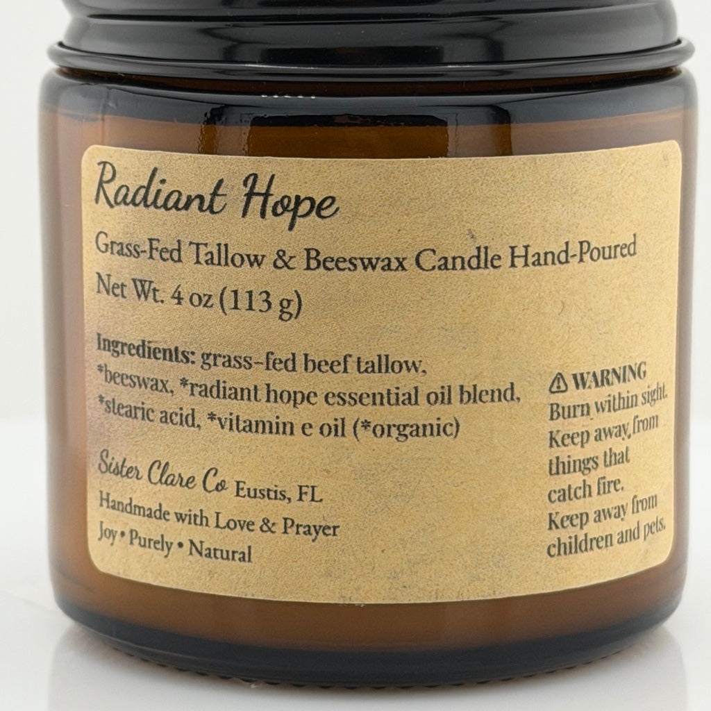 An amber glass jar candle with a black lid and a tan paper label reading 'Radiant Hope Grass-Fed Tallow & Beeswax Candle Hand-Poured' by Side Clave Co.