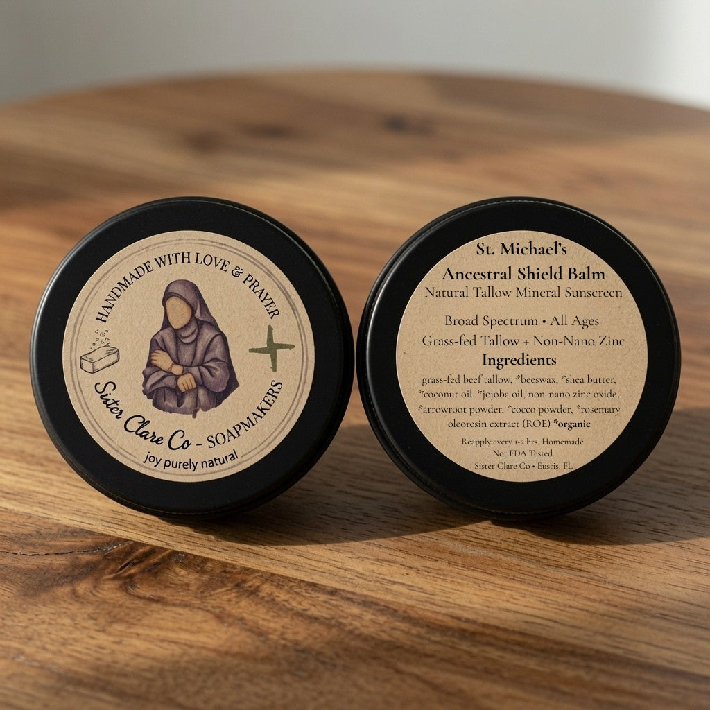 Two black tins of St. Michael's Ancestral Shield Balm on a wooden surface.