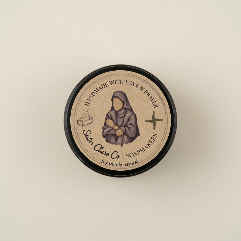 A round black-lidded jar of Sojour Clare Co. soap, viewed from directly above on a light beige background.