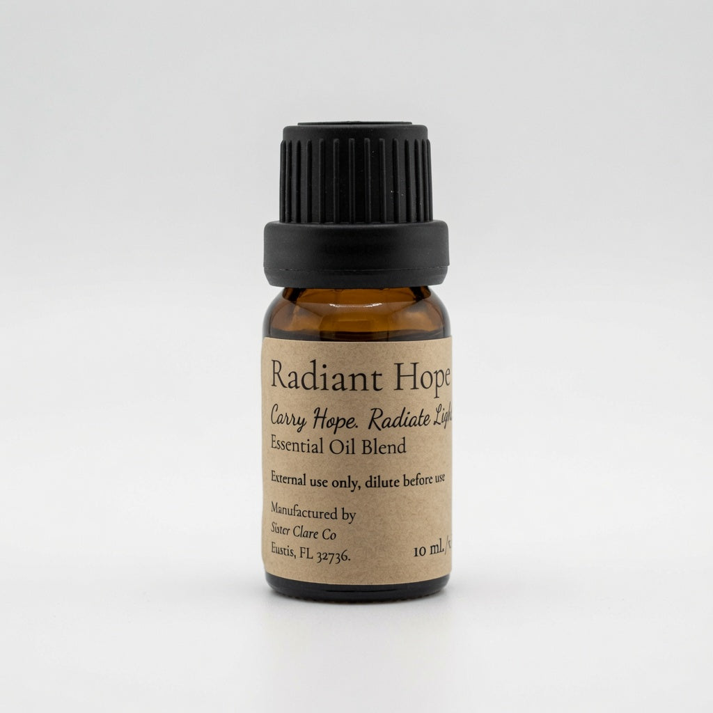 A 10 mL amber glass bottle of Radiant Hope Essential Oil Blend with a black ribbed cap and a beige paper label, photographed on a seamless light gray background.