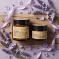 Overhead view of Joy Tallow Lotion in a vibrant light lavender-themed joyful setting with delicate flowers and natural elements