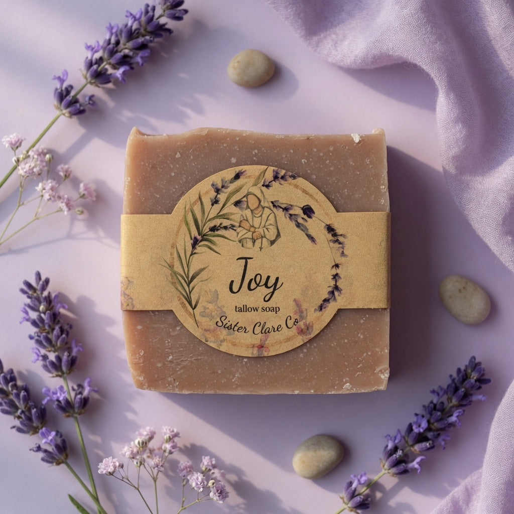 Bar of soap with a 'Joy' label surrounded by lavender flowers on a light background