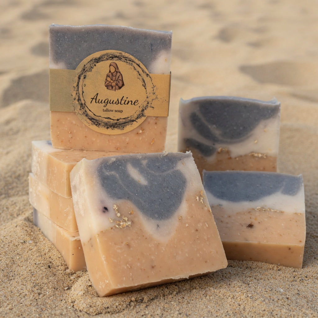 Handmade soap bars with a visible brand label on a sandy background